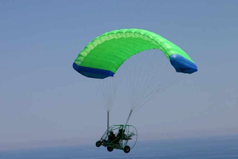 Infinity PPC flying with green chute with blue sky